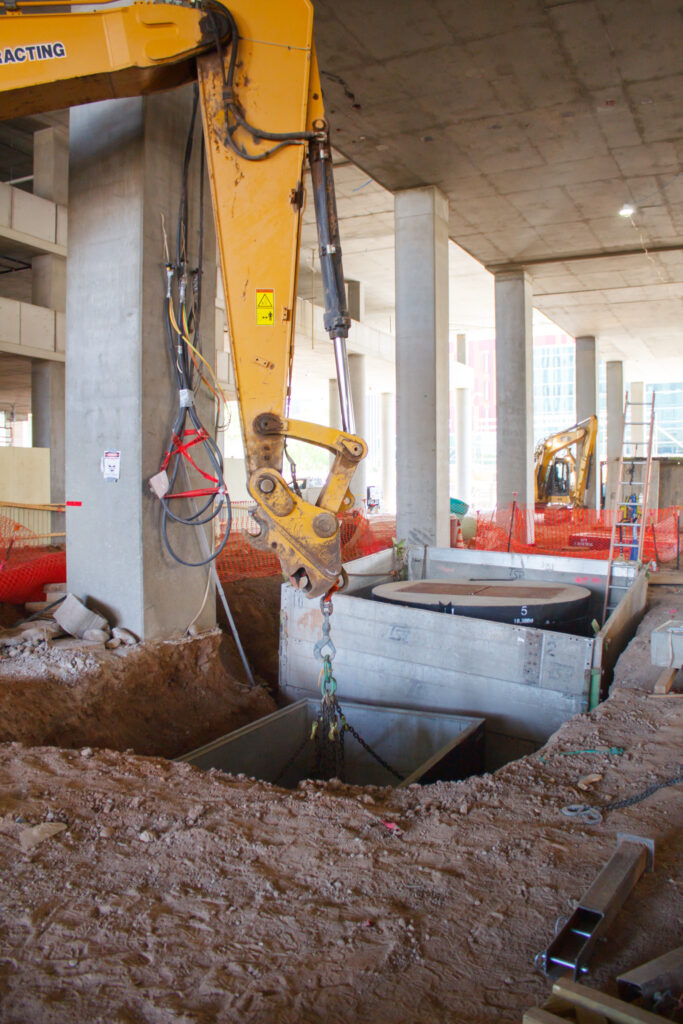 Equipment installing a lift station in jobsite