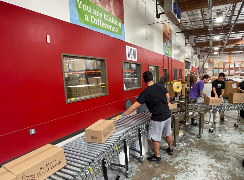 Conveyer belts with food boxes at a food bank