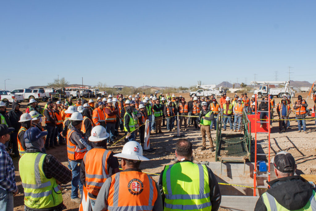 Group of workers gathered near a trench for safety