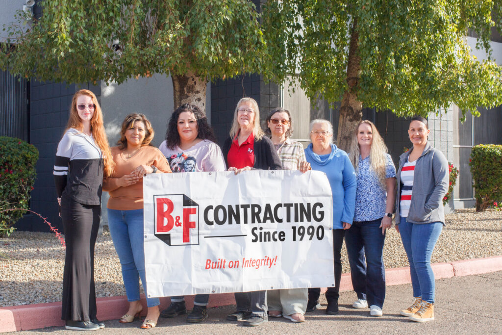 Women standing holding a banner